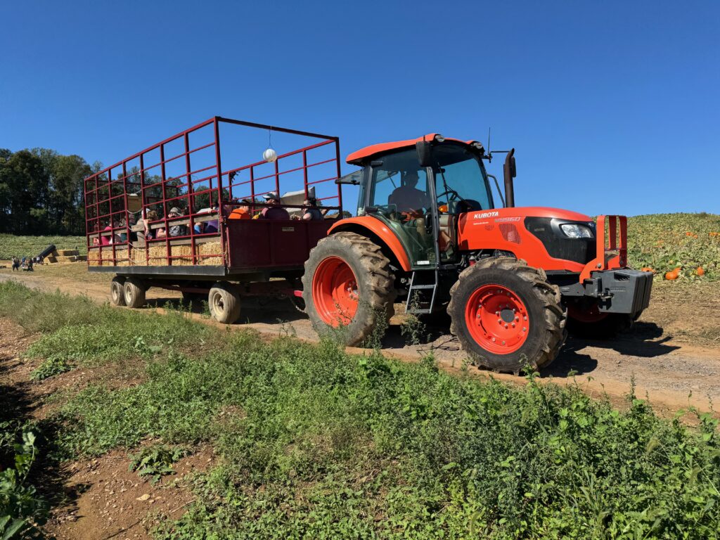 Kubota pulling hay wagon with people